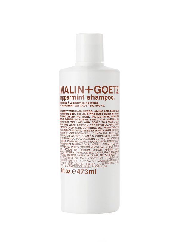 Champú de menta Malin + Goetz de 473 ml en botella blanca con texto en marrón, formulado con extracto de menta y limpiadores a base de aminoácidos para purificar el cabello y el cuero cabelludo.