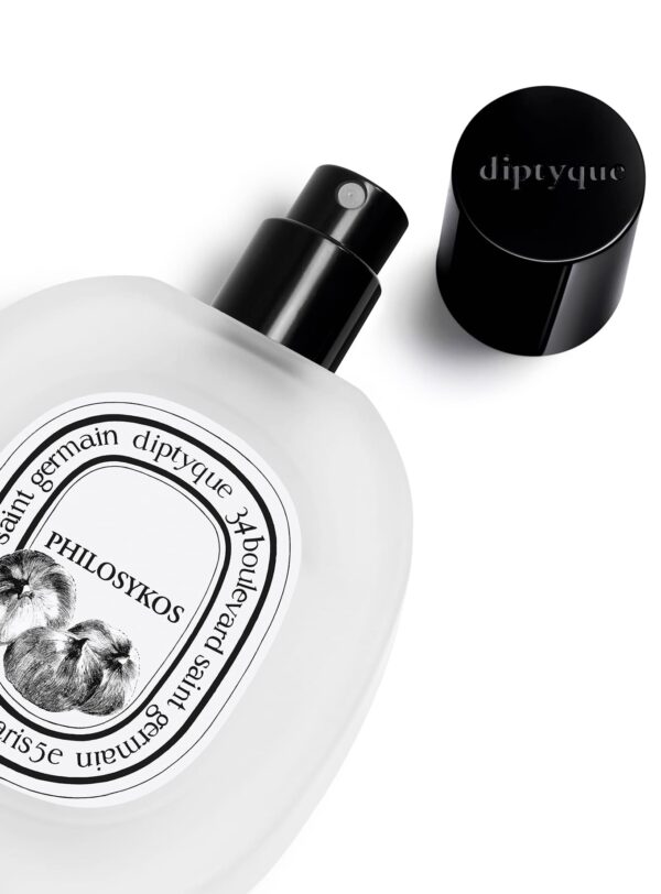 Frasco abierto del Hair Mist Philosykos de Diptyque con vaporizador negro, primer plano de la etiqueta y el tapón.