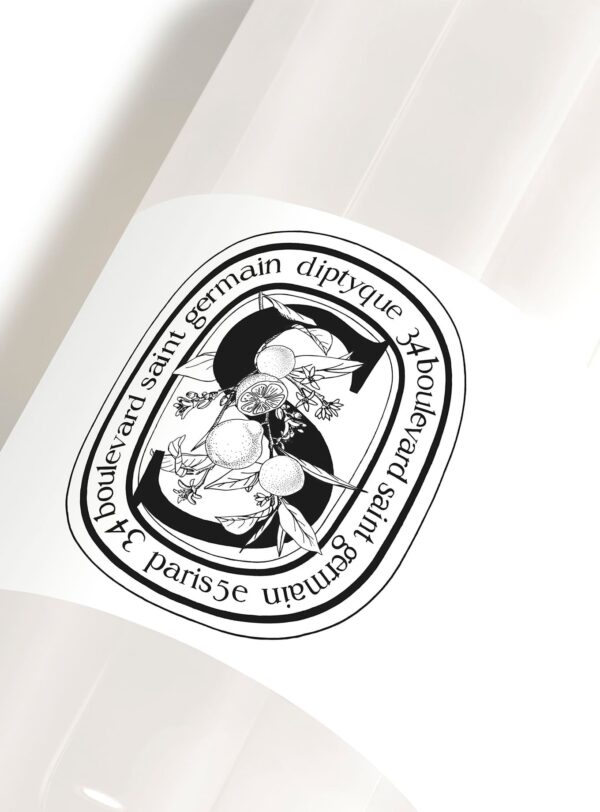 Primer plano del frasco de champú Diptyque con etiqueta ilustrada en blanco y negro, edición verano 2025.