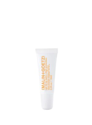 Bálsamo labial Malin+Goetz SPF30, tubo blanco de 10 ml con letras naranjas, hidratación y protección solar.