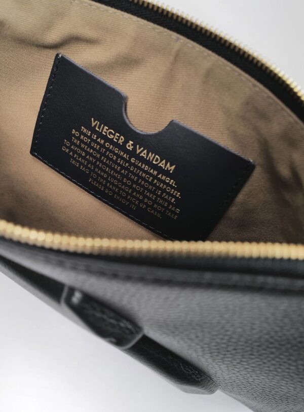 Interior del pouch Vlieger & Vandam con etiqueta y forro beige, detalle de diseño - Papaduk Ibiza
