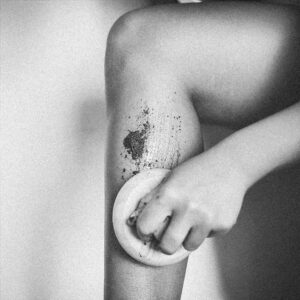 Aplicación de exfoliante corporal natural sobre pierna, imagen sensorial para rutina de cuidado de la piel
