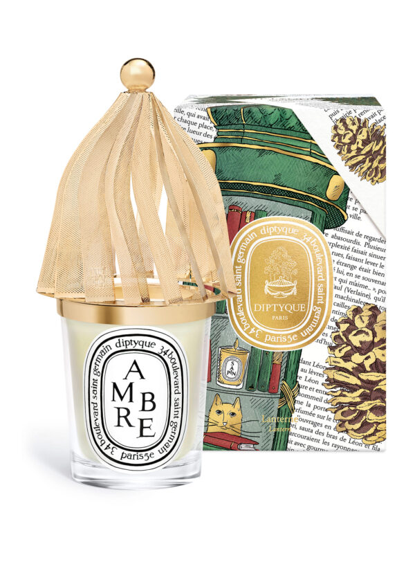 Diptyque Ambre Lantern Navidad 2025 – vela con tapa dorada junto a caja ilustrada, fragancia ambarada y elegante.