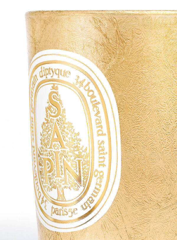 Diptyque Sapin Vela Dorada 70g – detalle de la etiqueta dorada con árbol grabado, fragancia invernal.