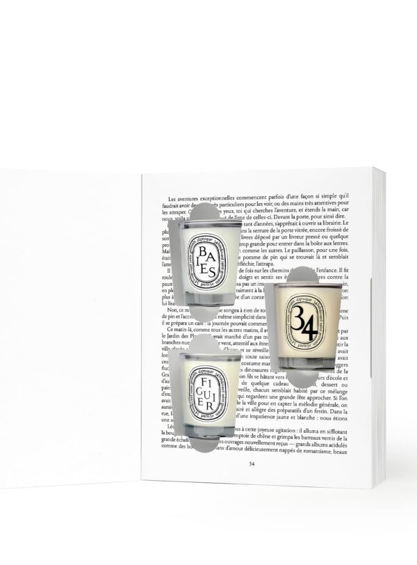 Diptyque Coffret Mini Velas Navidad 2025 – libro abierto con tres velas perfumadas Baies, Figuier y 34 presentadas sobre páginas impresas.