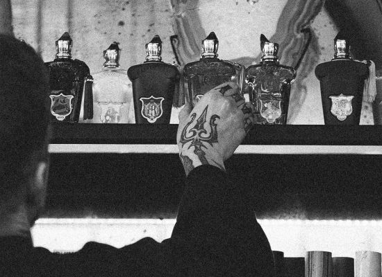 Persona observando perfumes en estantería, comparación entre perfumería nicho y perfume comercial