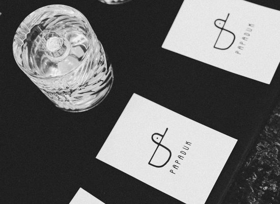 Frascos de perfume sobre una superficie oscura junto a tarjetas de Papaduk, representando la conservación y duración de las fragancias abiertas.